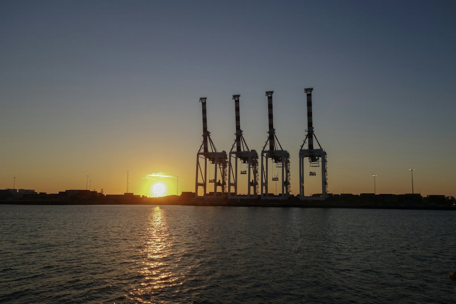 Container cranes at a harbour at sunset